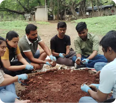 Group preparing seedballs together during environmental initiative 